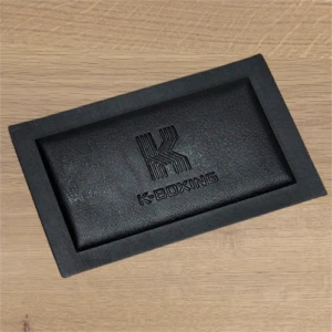 black leather label with debossed letter logo