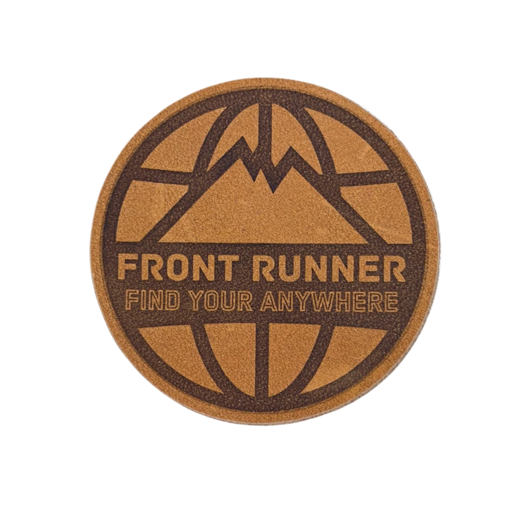 brown circle laser engraved leather patch with globe and mountain design