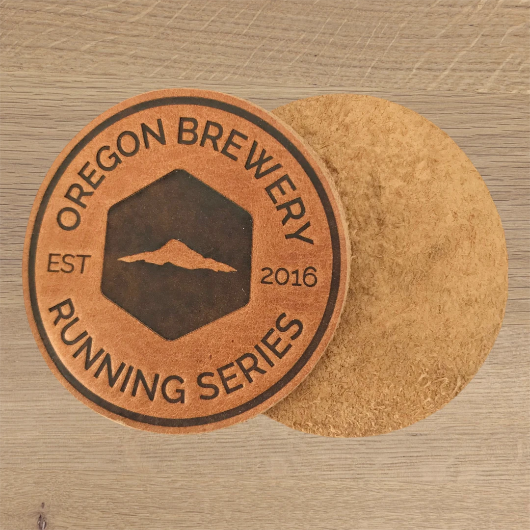 brown circle leather patch with engraved brewery logo showing front and back