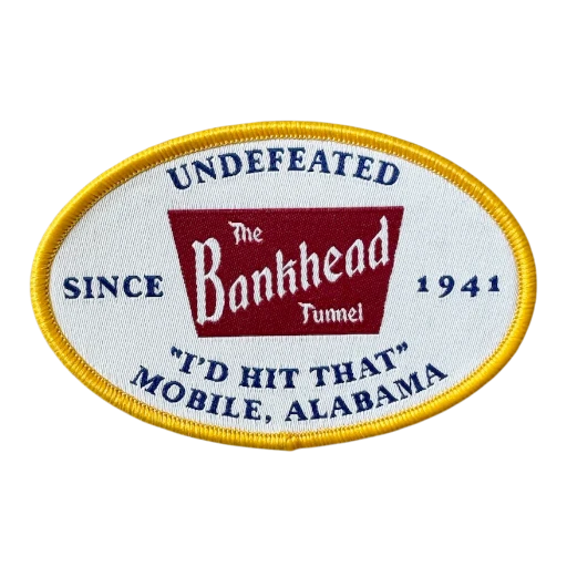 white oval woven patch with red logo and yellow merrow border