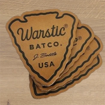 tan arrowhead shape leather patch with debossed brand logo