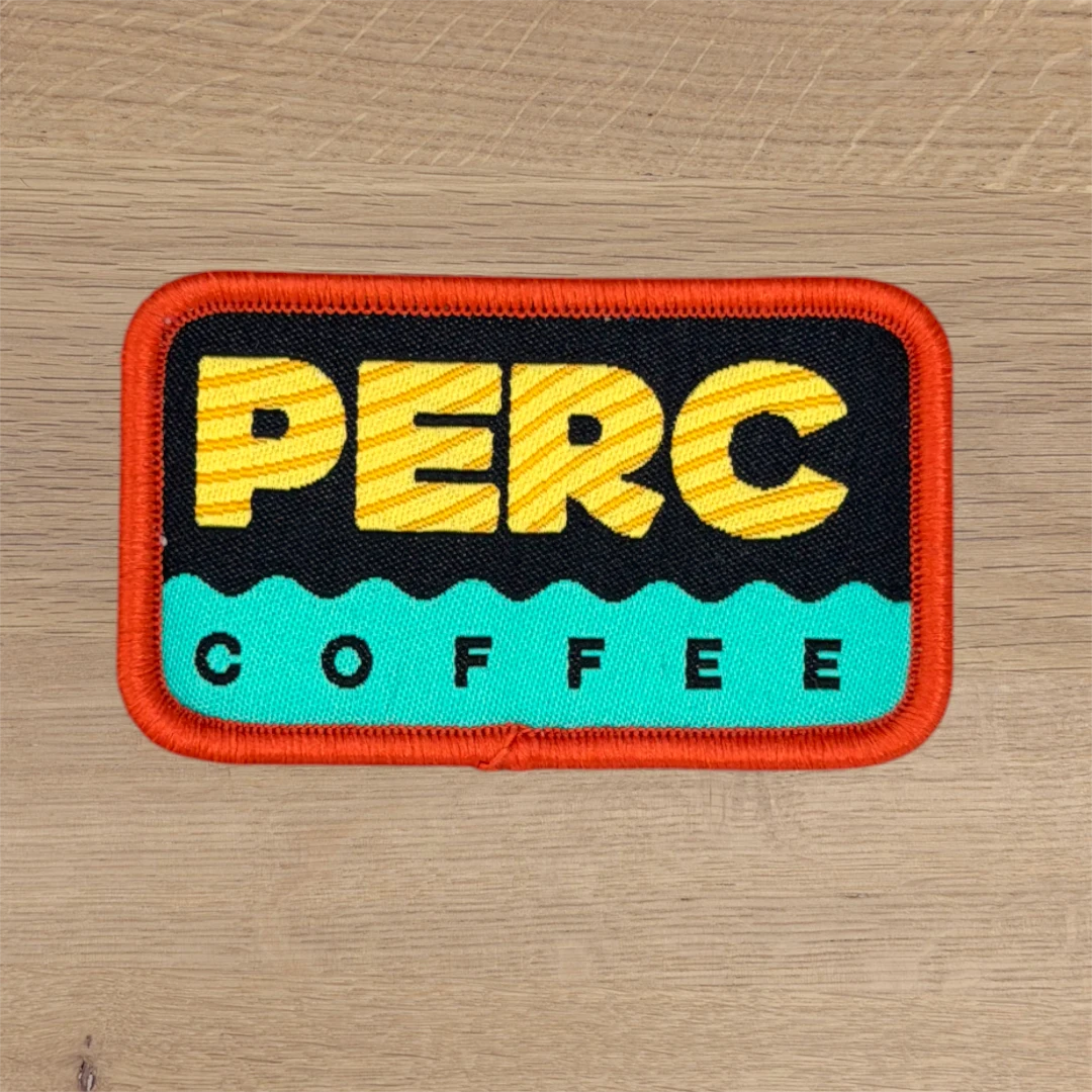 woven patch with orange merrow border and yellow coffee brand lettering