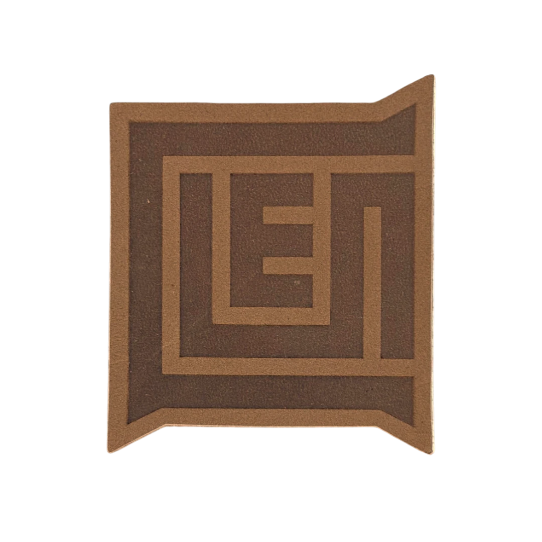 taupe leather patch cut to custom logo shape with engraved monogram